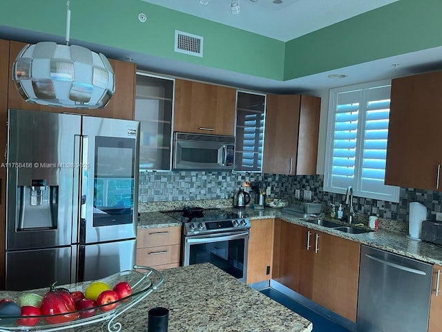 kitchen with stainless steel appliances, visible vents, a sink, and decorative backsplash