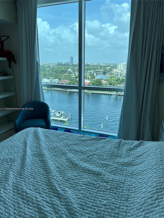 bedroom featuring a view of city and a water view