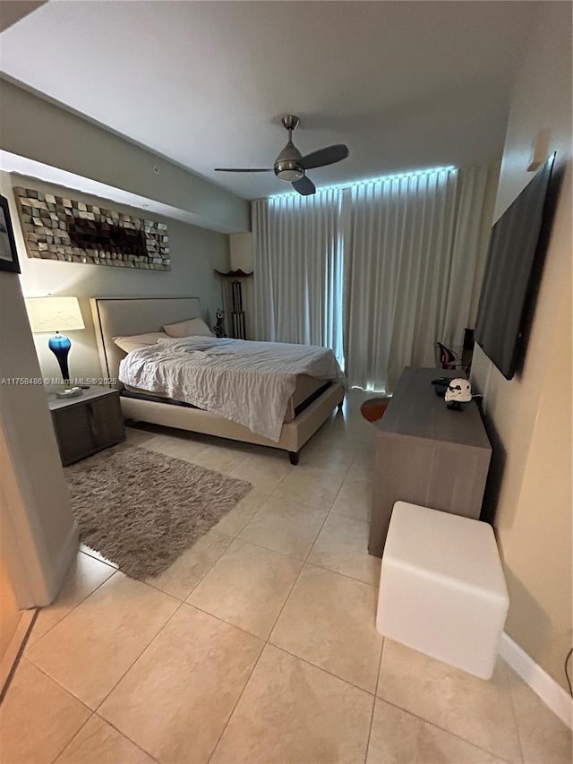 bedroom featuring light tile patterned floors, ceiling fan, and baseboards