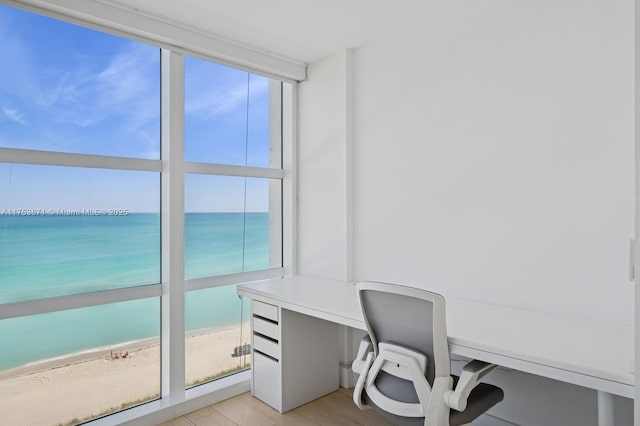 home office with a water view, a beach view, and built in desk