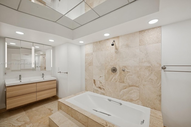 bathroom featuring a relaxing tiled tub, double vanity, recessed lighting, a tile shower, and a sink