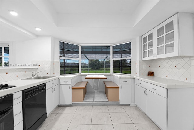 8790 SW 84th St, Miami, FL 33173 - kitchen with black appliances, white cabinetry, tile counters, and a sink