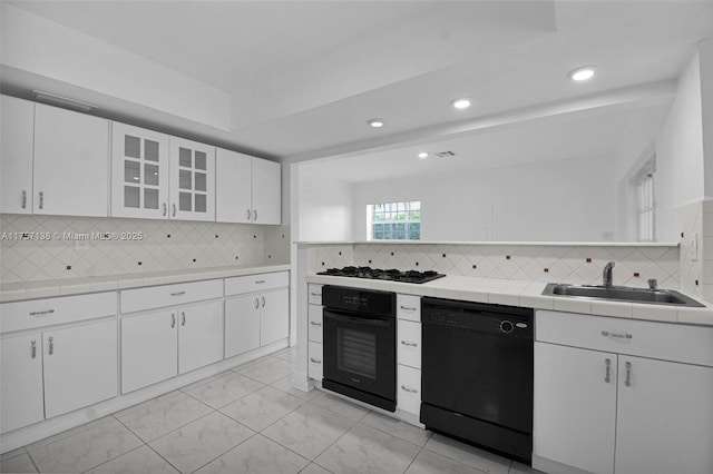 8790 SW 84th St, Miami, FL 33173 - kitchen featuring tasteful backsplash, white cabinets, tile countertops, black appliances, and a sink