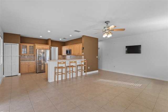 kitchen featuring visible vents, open floor plan, decorative backsplash, a peninsula, and stainless steel appliances