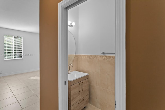 bathroom with tile patterned flooring, a wainscoted wall, tile walls, and vanity