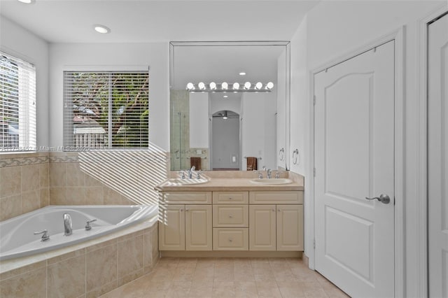 full bathroom featuring a garden tub, a sink, a shower stall, tile patterned flooring, and double vanity