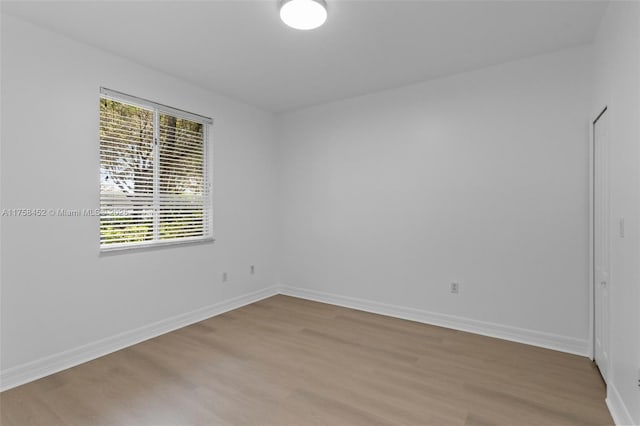 spare room with light wood-style flooring and baseboards