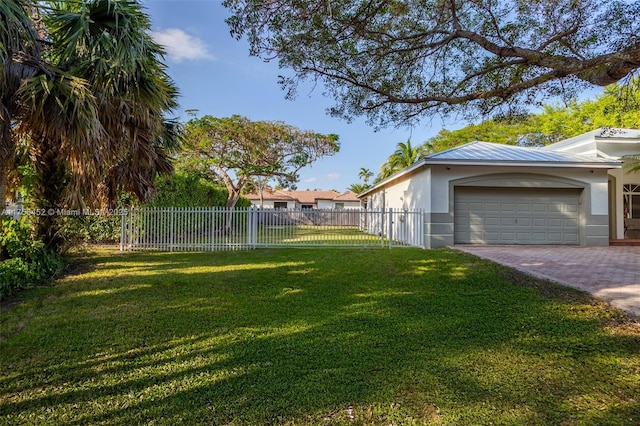 view of yard with decorative driveway and fence