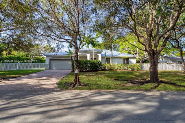 view of front of house with a front lawn, fence, stucco siding, decorative driveway, and an attached garage