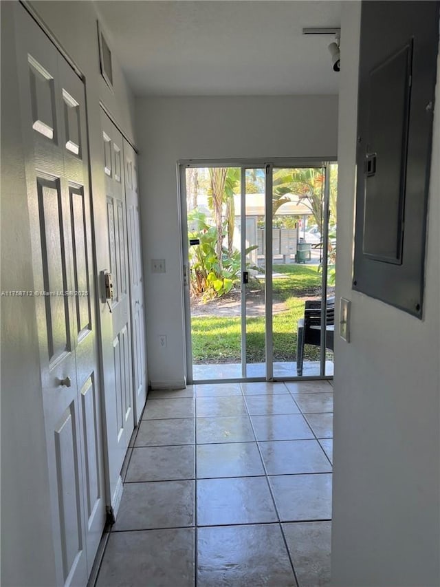 doorway featuring visible vents, light tile patterned floors, and electric panel