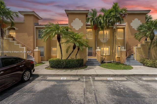 property at dusk with uncovered parking