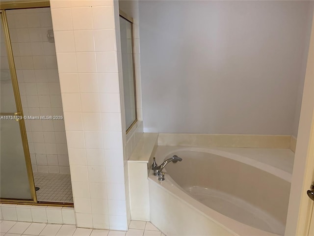 bathroom with a stall shower, a garden tub, and tile patterned floors