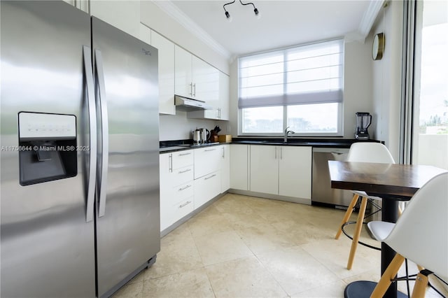 kitchen featuring under cabinet range hood, stainless steel appliances, ornamental molding, and white cabinets