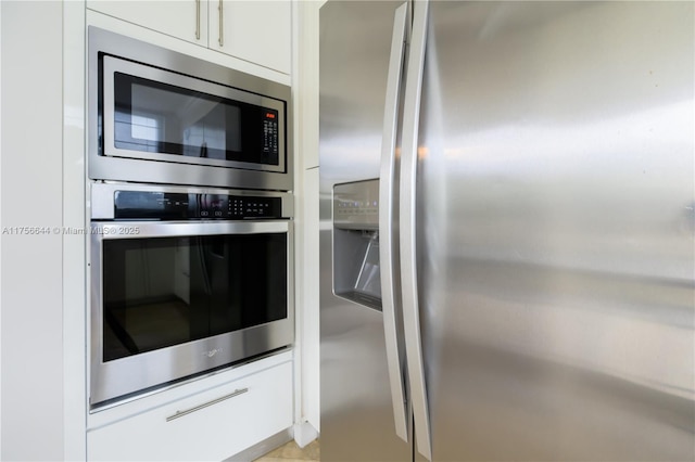 kitchen with stainless steel appliances and white cabinetry