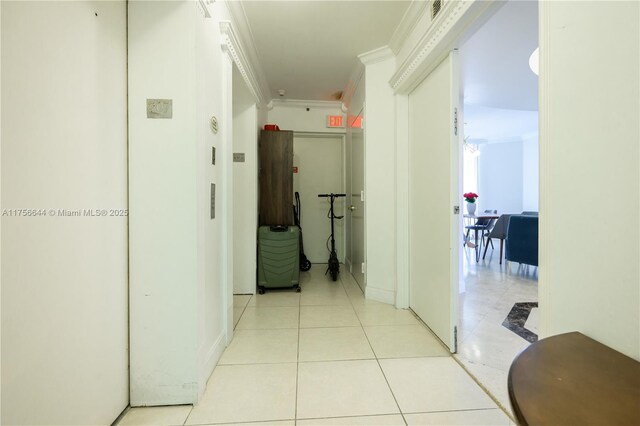 hallway with crown molding and light tile patterned flooring