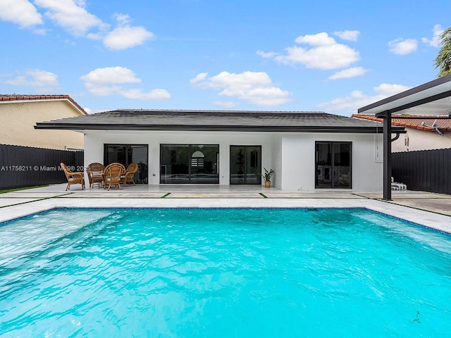 view of swimming pool with a patio area, fence, and a fenced in pool