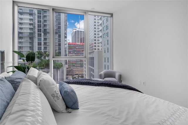 bedroom featuring a view of city and floor to ceiling windows