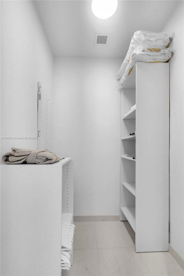 walk in closet featuring marble finish floor and visible vents