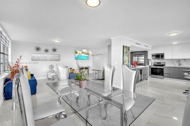 dining room featuring marble finish floor and ornamental molding