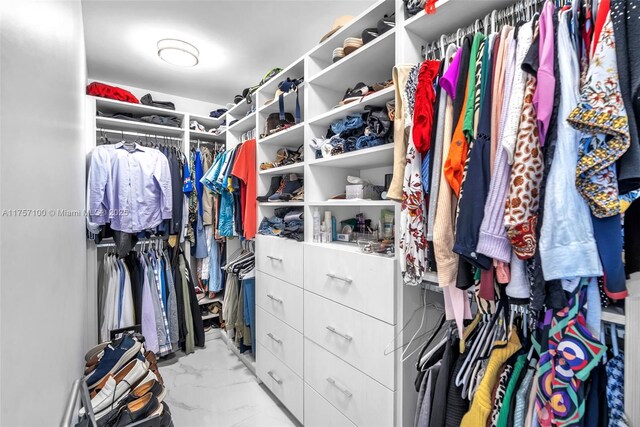 walk in closet with marble finish floor