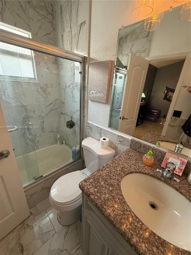 full bath with toilet, a textured wall, vanity, shower / bath combination with glass door, and marble finish floor