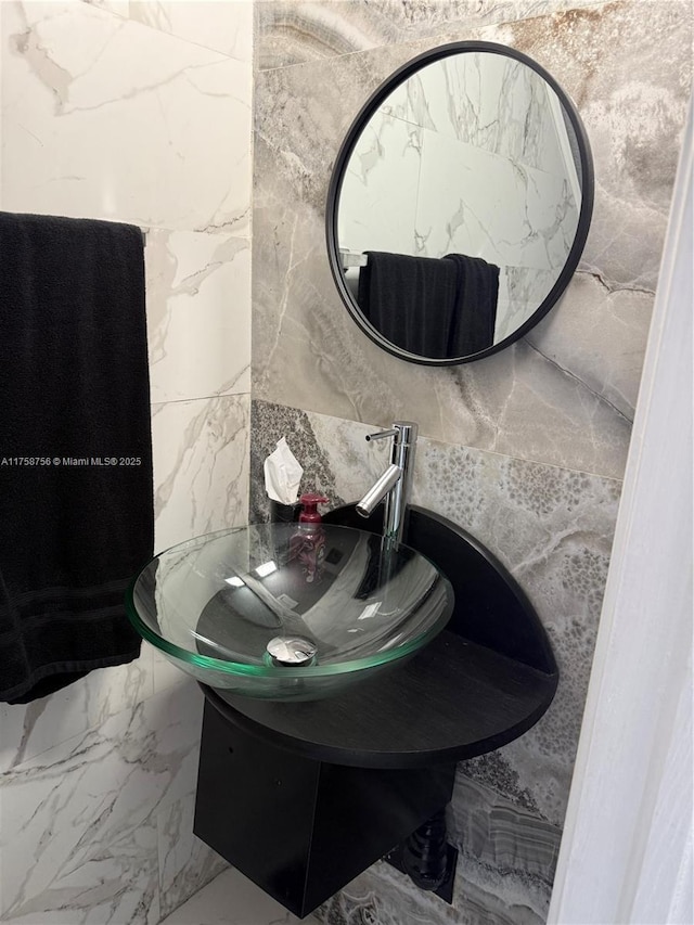 bathroom with marble finish floor and a sink