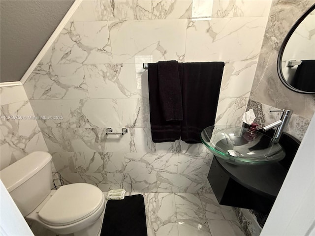 bathroom featuring toilet, marble finish floor, and vanity