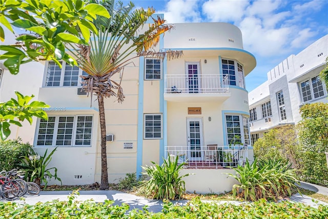 art deco home with crawl space, a balcony, and stucco siding