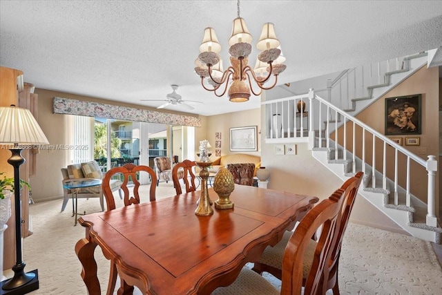 dining room with carpet, stairway, a textured ceiling, and ceiling fan with notable chandelier