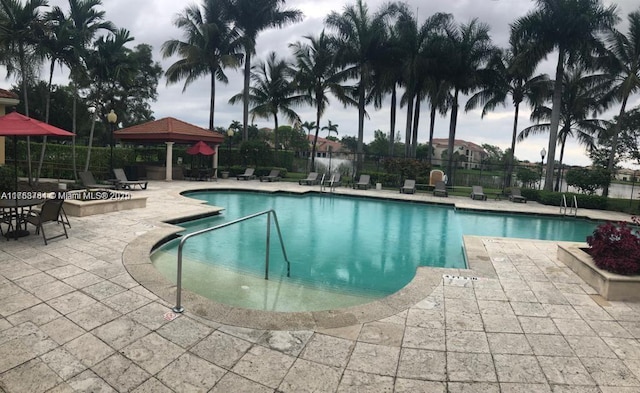 pool with a gazebo, a patio area, and fence