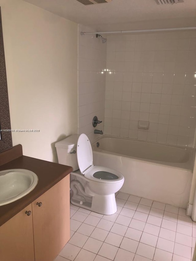 bathroom featuring shower / bathtub combination, toilet, vanity, and tile patterned floors