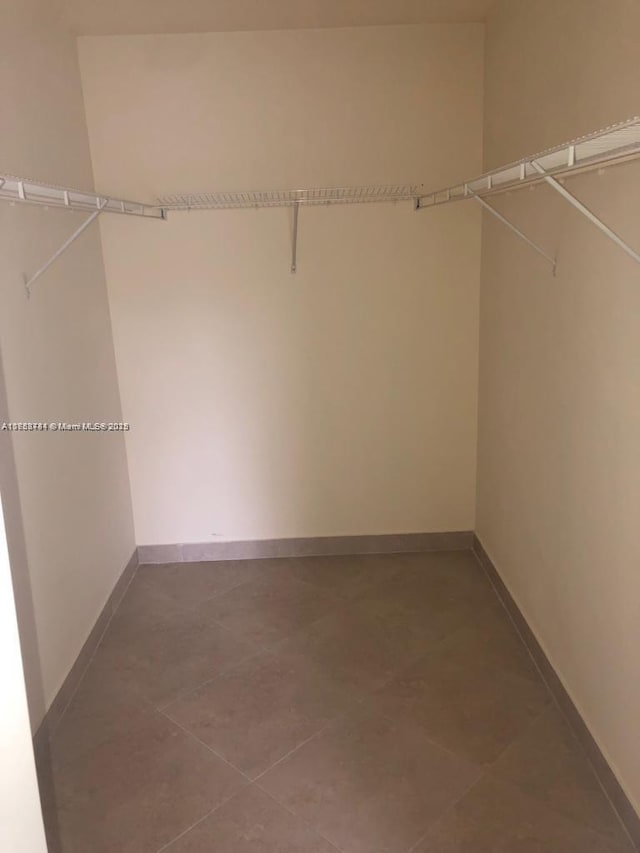 walk in closet featuring tile patterned flooring