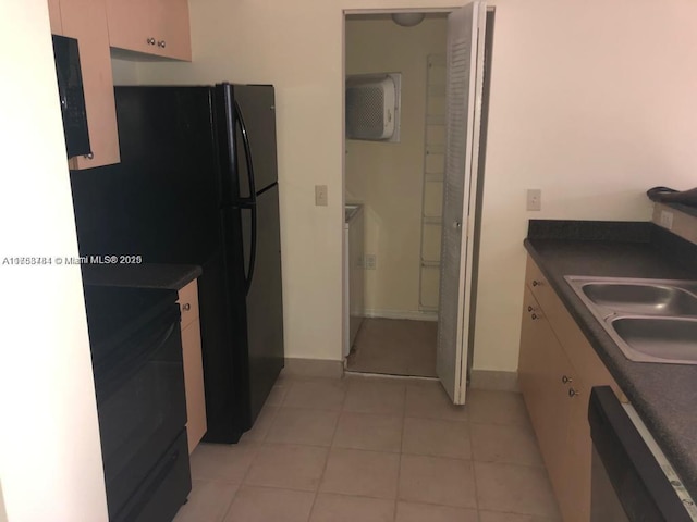 kitchen with light tile patterned floors, a sink, range, dishwasher, and dark countertops