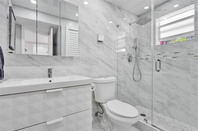 full bath with toilet, vanity, tile walls, marble finish floor, and a marble finish shower