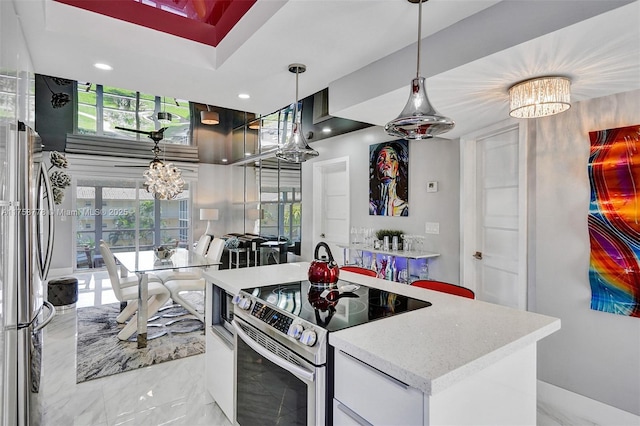 kitchen featuring marble finish floor, stainless steel appliances, hanging light fixtures, a kitchen island, and a chandelier