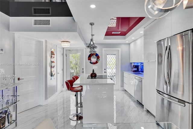 kitchen with visible vents, white cabinets, a raised ceiling, modern cabinets, and appliances with stainless steel finishes