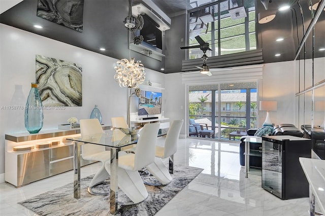 dining area with a towering ceiling, marble finish floor, wine cooler, and a notable chandelier