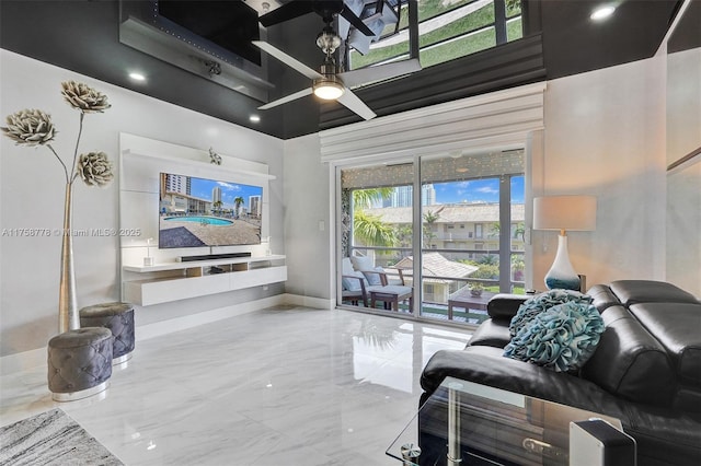 living room featuring marble finish floor, a high ceiling, and baseboards