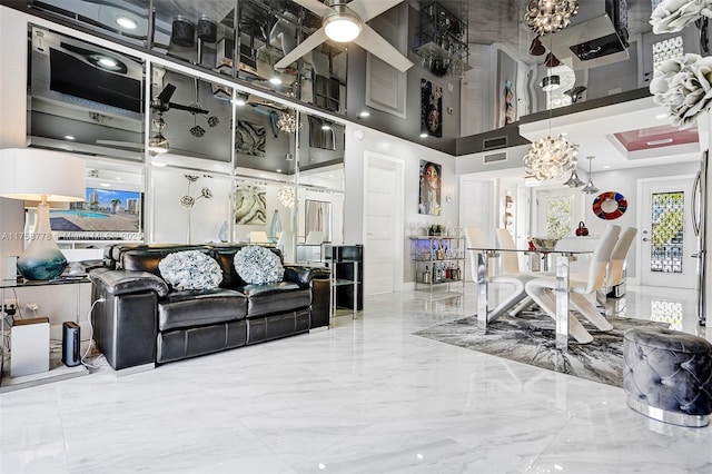 living area featuring a ceiling fan, marble finish floor, visible vents, and a high ceiling