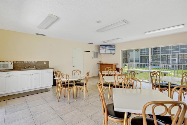 dining room featuring light tile patterned floors, a textured ceiling, and visible vents