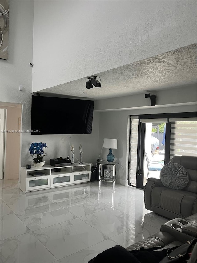 living area featuring marble finish floor and a textured ceiling