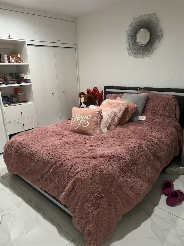 bedroom featuring a closet and marble finish floor