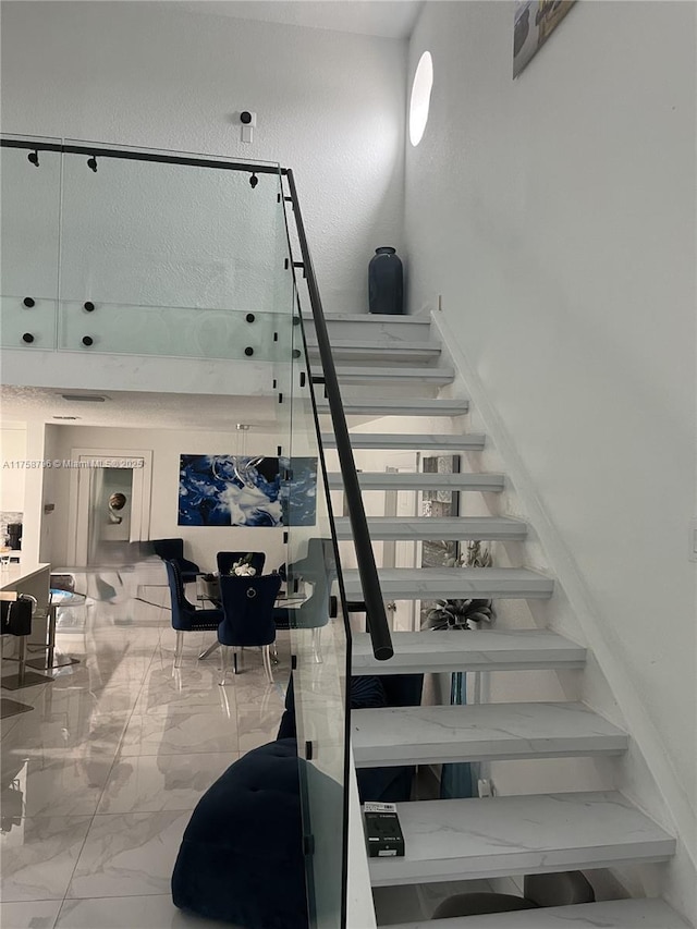 staircase featuring marble finish floor