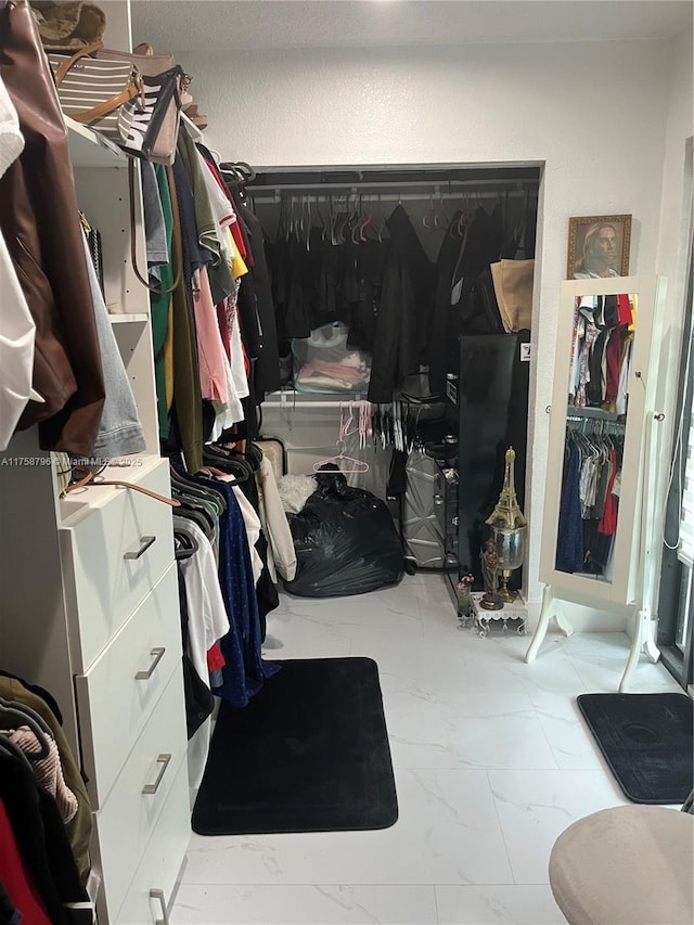 spacious closet with marble finish floor