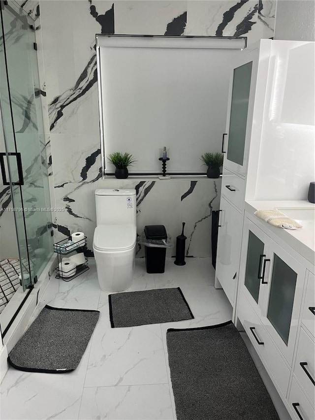 bathroom with marble finish floor, vanity, a marble finish shower, and toilet