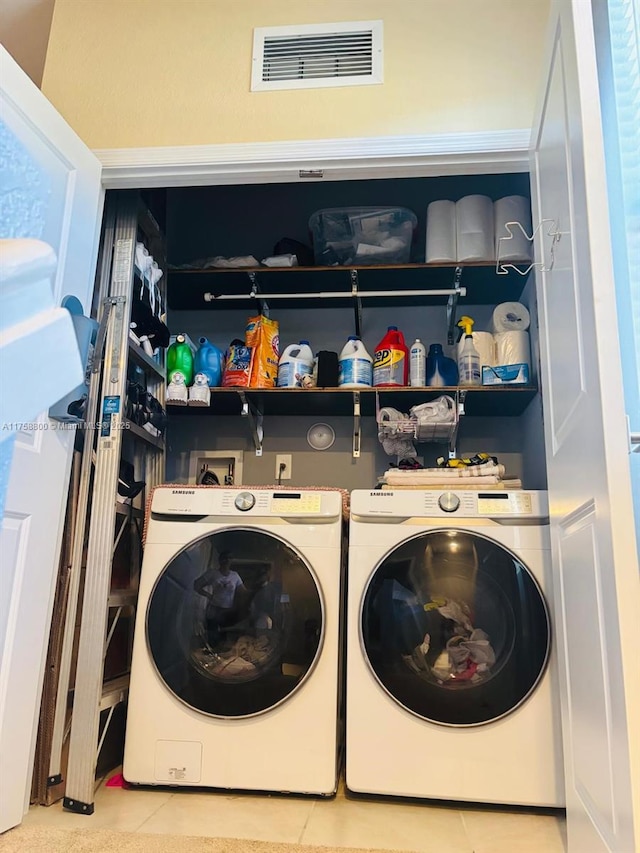 clothes washing area with laundry area, tile patterned flooring, visible vents, and separate washer and dryer