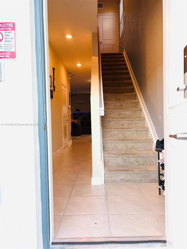 stairway featuring recessed lighting, visible vents, baseboards, and tile patterned floors