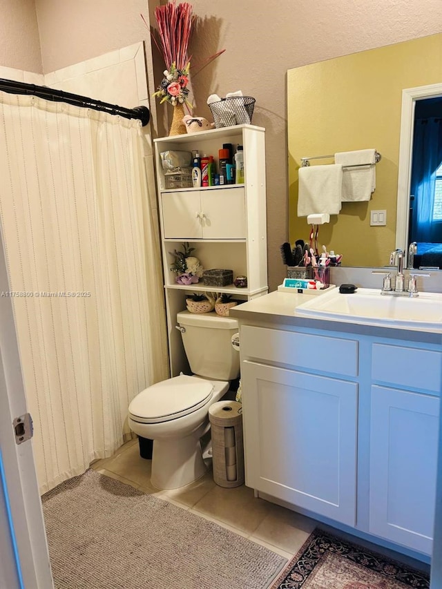 bathroom featuring toilet, curtained shower, vanity, and tile patterned floors