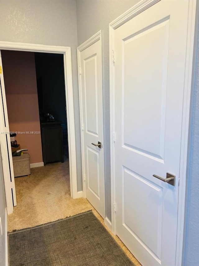 corridor with carpet floors and baseboards