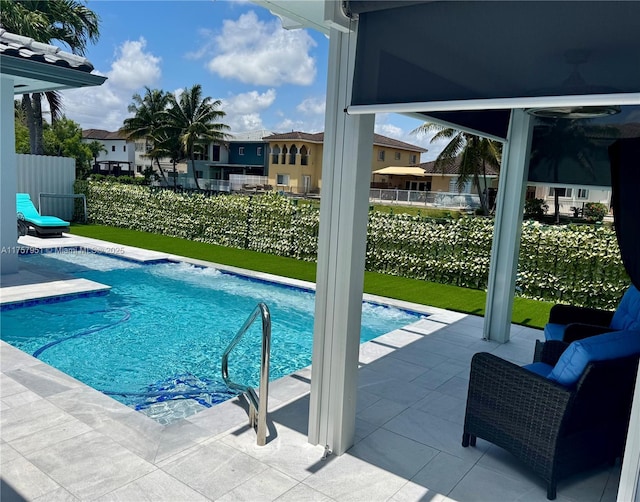 view of swimming pool with a patio and fence